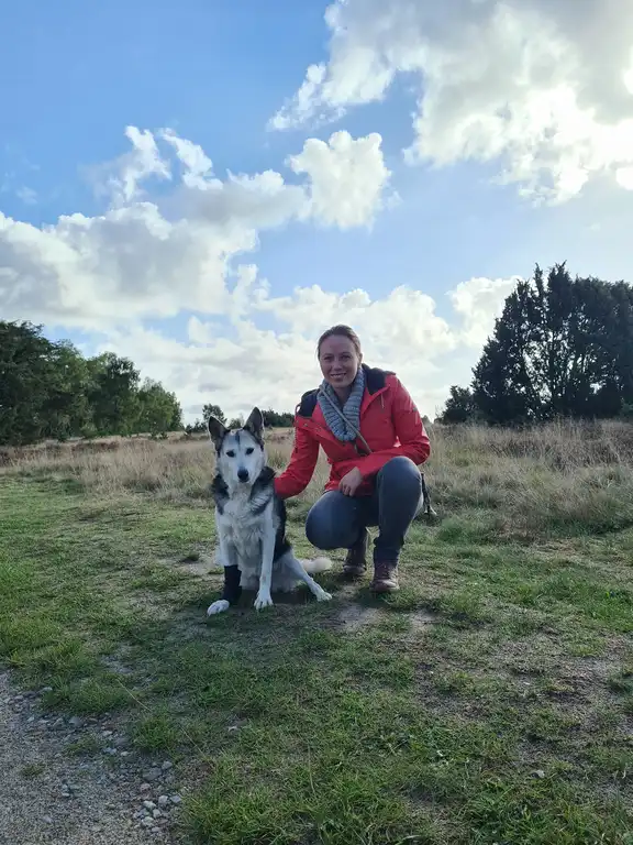 Lächelnde Frau mit Kaffeetasse im hellen Büro.